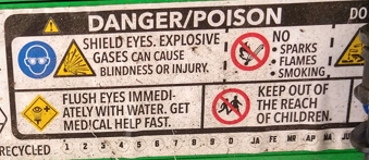 A precautions sticker on a battery that reads "Danger/Poison. Shield eyes. Explosive gases can cause blindness or injury. No sparks, flames, or smoking. Keep out of the reach of children, and flush eyes immediately with water. Get medical help fast."