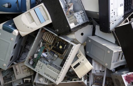 A bunch of computers, some broken apart, scattered on top of one another